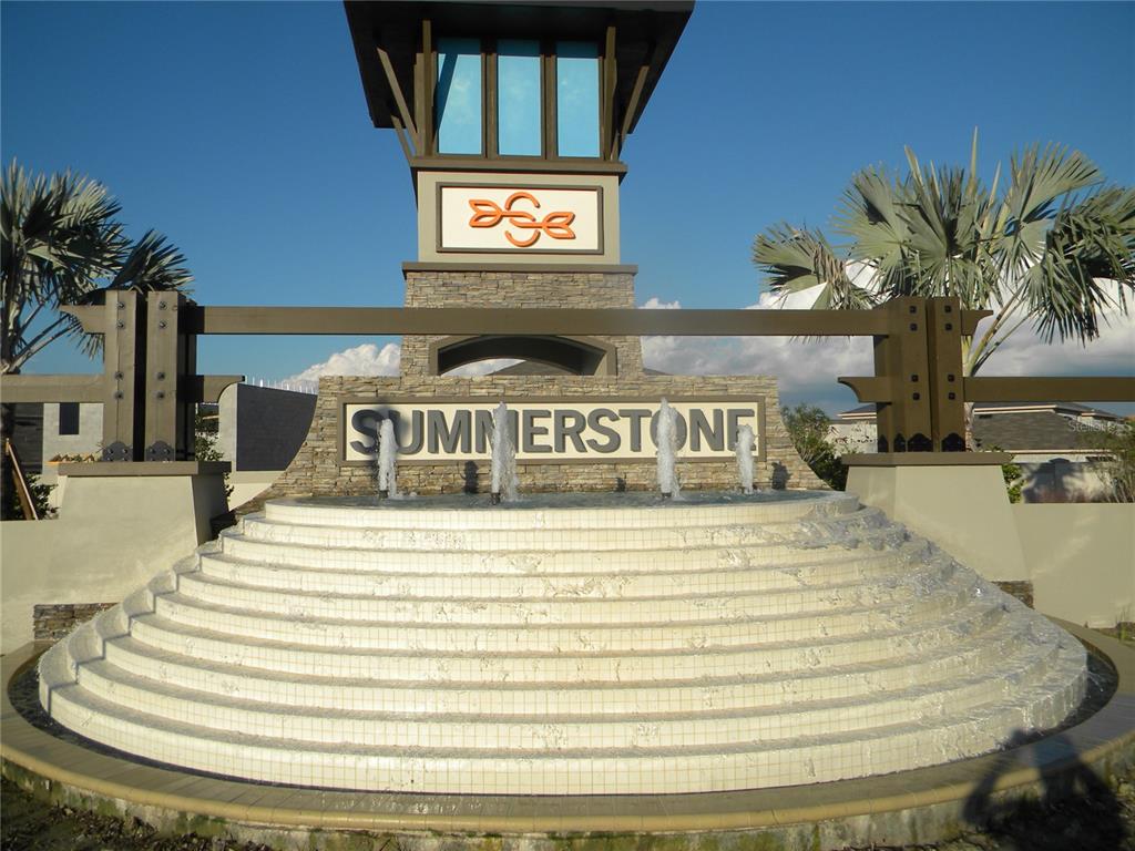 A stone monument with a tiered fountain and the name Summerstone stands under a blue sky — 34274 JASPER STONE DRIVE, WESLEY CHAPEL, FL