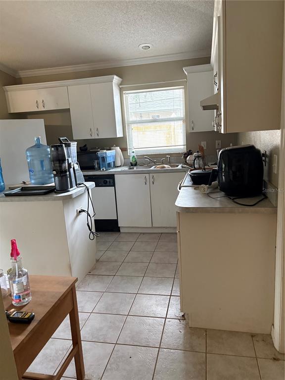 A kitchen features white cabinets, tile flooring, a window above the sink, and counter appliances — 3743 WAKE AVENUE, SARASOTA, FL