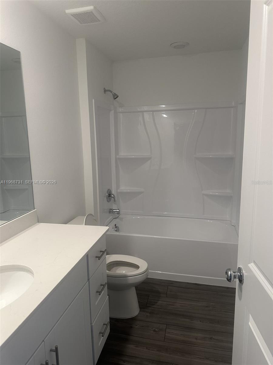A bathroom features a white vanity, a toilet, and a white bathtub-shower combination — 13110 SW 89TH ST, Ocala FL 34432, OCALA, FL