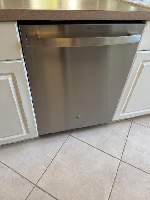 A stainless steel GE dishwasher is installed between white cabinets in a tiled kitchen — 500 Egret Circle # 8211, Delray Beach FL 33444, DELRAY BEACH, FL