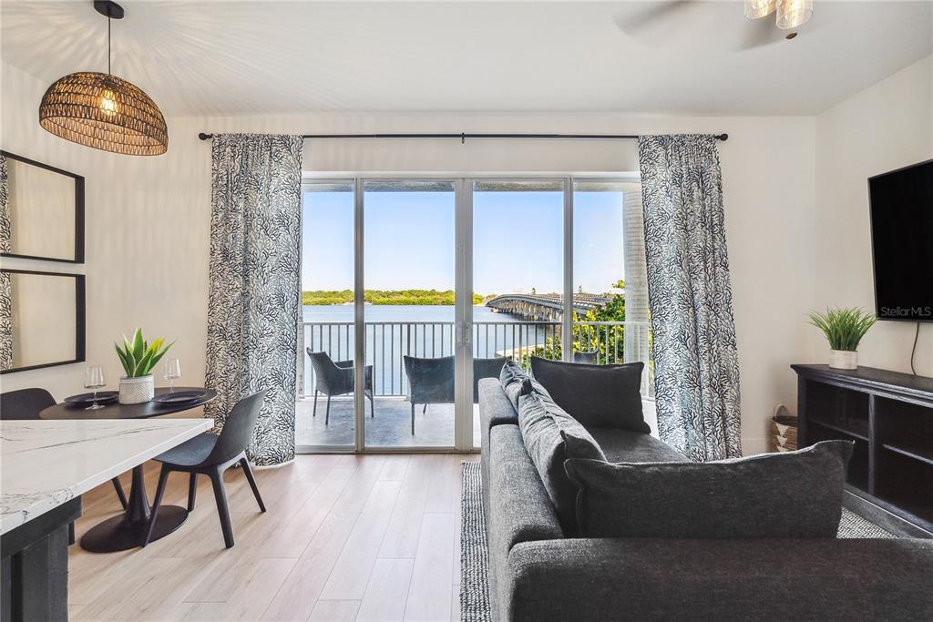 A living and dining area features a balcony with water views and a bridge — 8800 BAY PINES BOULEVARD UNIT 102, ST PETERSBURG, FL