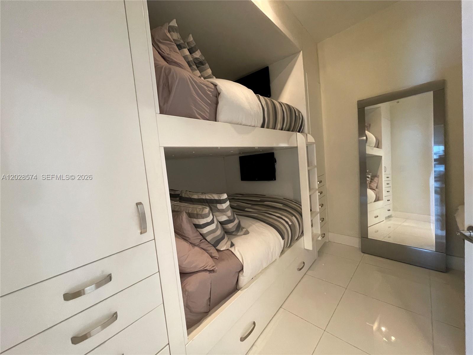 A bedroom features built-in white bunk beds, a tall mirror, and light-colored tile flooring — 2020 N Bayshore Dr # 2008, Miami FL 33137, MIAMI, FL