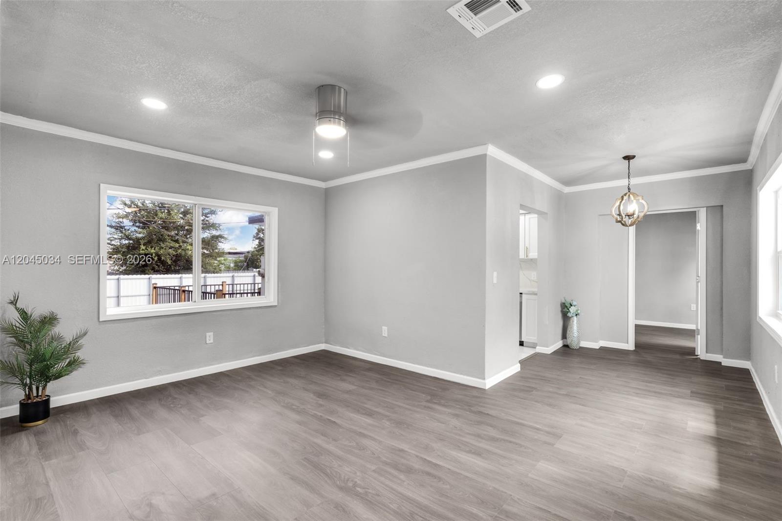 A living room features gray walls, wood-look flooring, a ceiling fan, and recessed lighting — 1246 Fisherman St, Opa-Locka FL 33054, OPA-LOCKA, FL