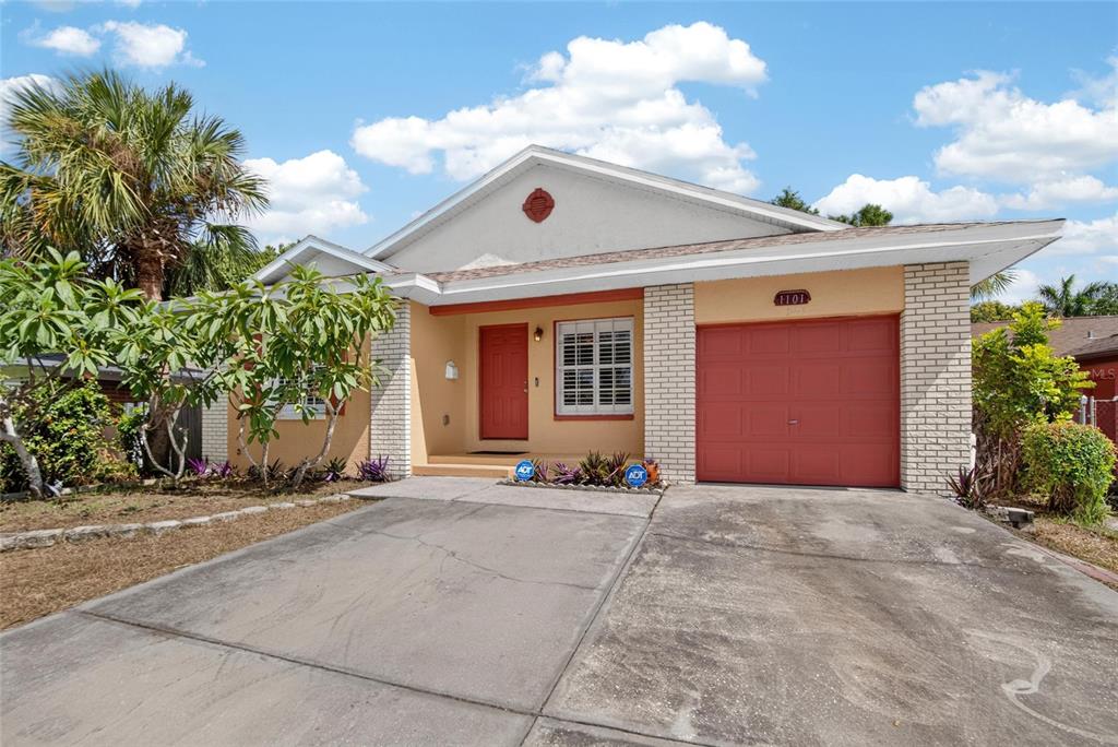 A single-story house with a tan exterior, red garage door, and a concrete driveway — 1101 27TH AVENUE S, ST PETERSBURG, FL