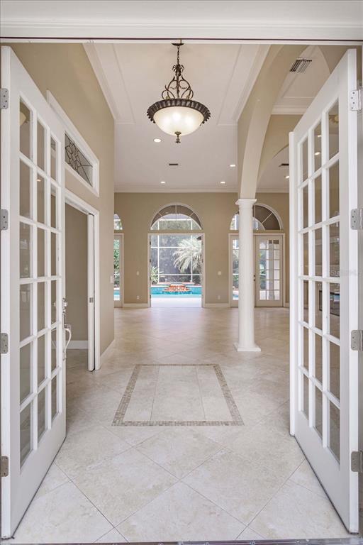 An entryway with tile flooring leads to an open living area overlooking a swimming pool — 4965 SHORELINE CIRCLE, SANFORD, FL