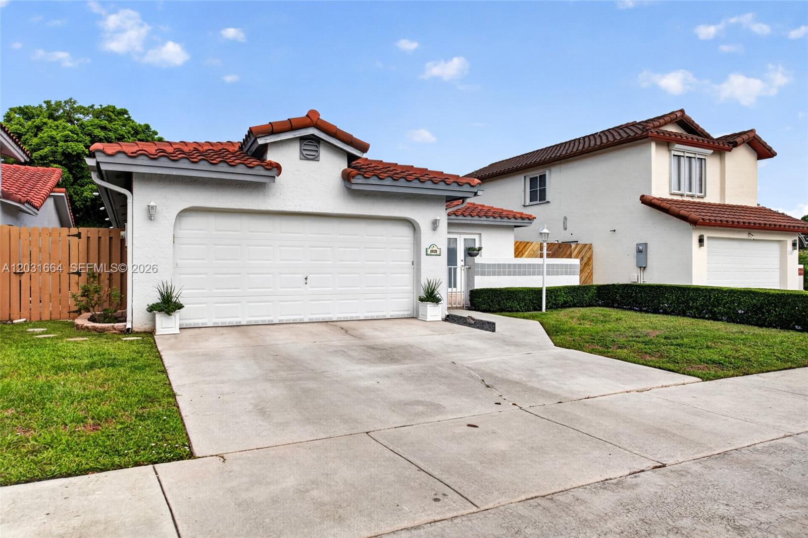 A single-story house with a white stucco exterior, red tile roof, and a two-car garage — 11038 SW 148th Pl, Miami FL 33196, MIAMI, FL