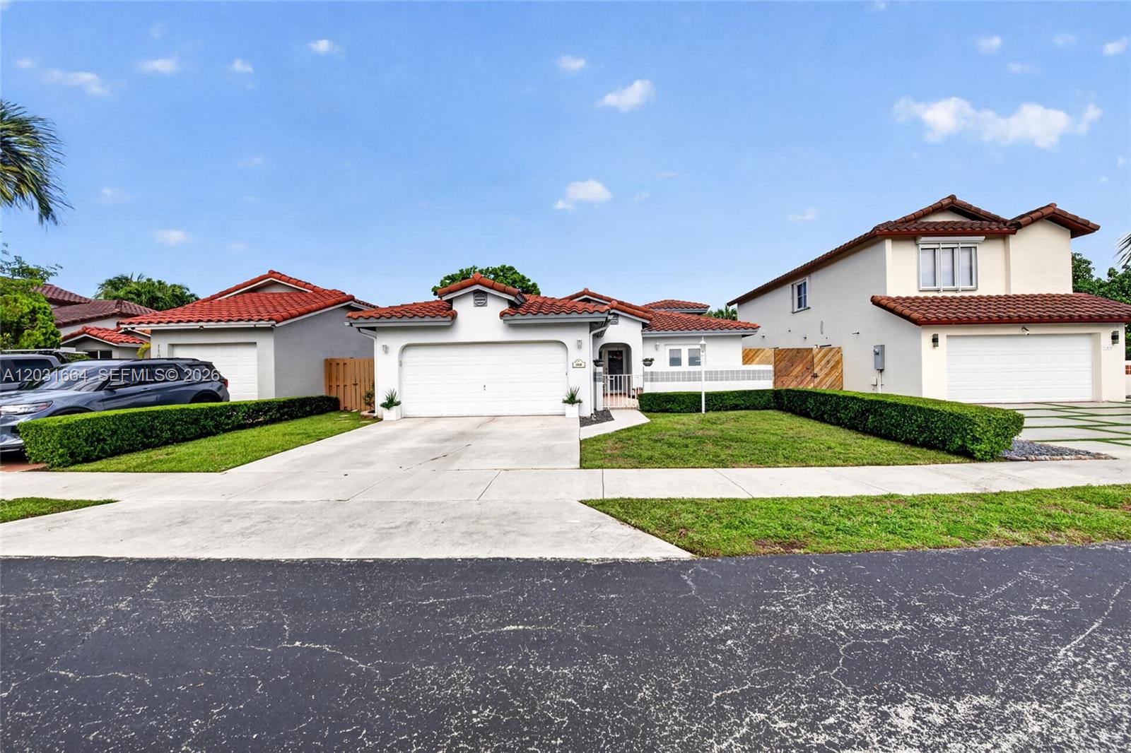 A single-story house with a white stucco facade, red tile roof, and a two-car garage — 11038 SW 148th Pl, Miami FL 33196, MIAMI, FL