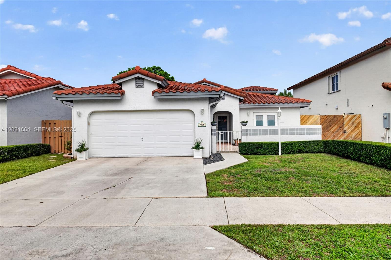 A single-story house with a white stucco exterior, red tile roof, and a two-car garage — 11038 SW 148th Pl, Miami FL 33196, MIAMI, FL
