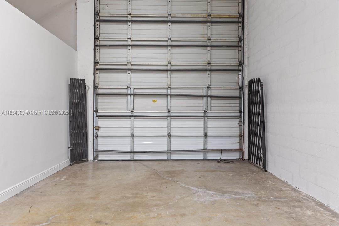 This industrial space features a high roll-up metal door and concrete flooring — 1501 NW 82nd Ave, Doral FL 33126, DORAL, FL