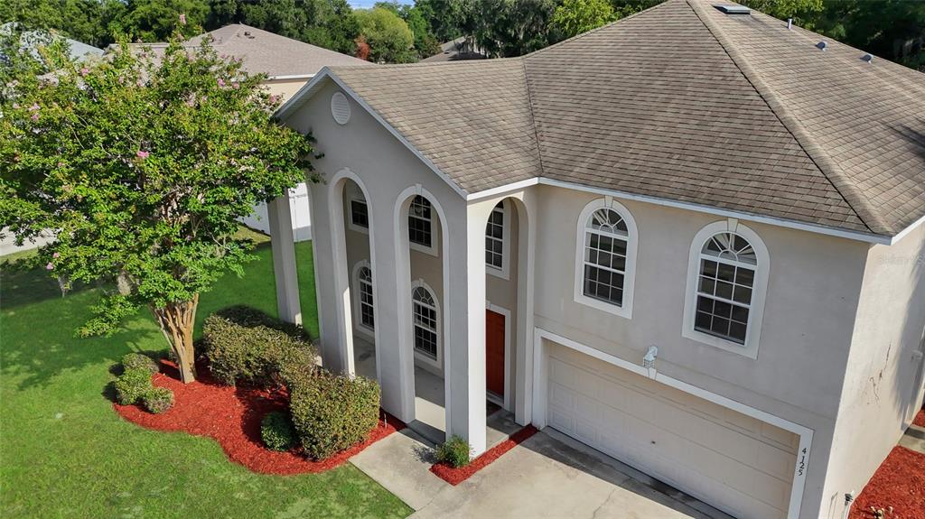 An elevated view shows a two-story house with a beige stucco exterior and arched entryways — 4125 SW 33RD STREET, OCALA, FL