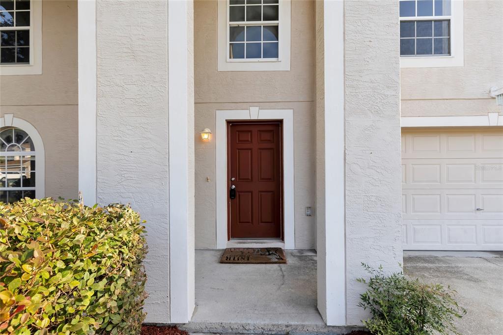 A brown front door is centered between white columns on the exterior of a house — 4125 SW 33RD STREET, OCALA, FL