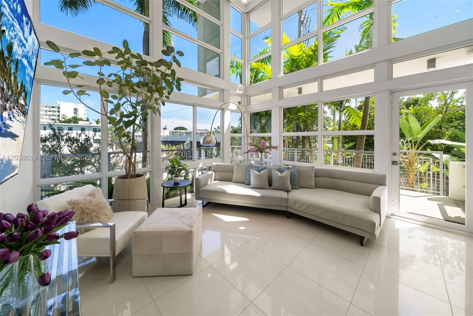 A sunlit living room features floor-to-ceiling windows, white tile flooring, and a large sectional sofa — 39 N Shore Dr, Miami Beach FL 33141, MIAMI BEACH, FL