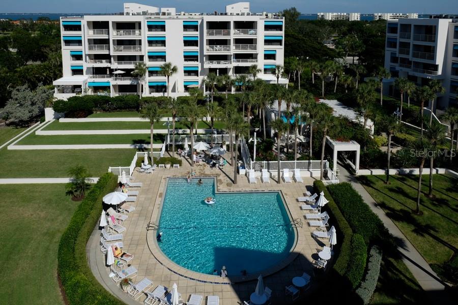 An aerial view shows a swimming pool surrounded by lounge chairs and palm trees — 2105 GULF OF MEXICO DRIVE UNIT 3404, LONGBOAT KEY, FL
