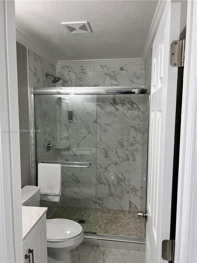 A bathroom features a glass-enclosed shower with marble-look tile walls and a pebble floor — 2240 Simms St, Hollywood FL 33020, HOLLYWOOD, FL