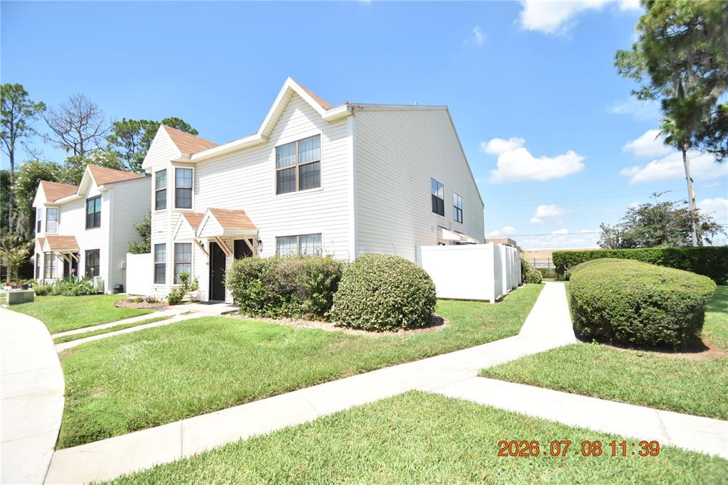 A two-story, light-colored vinyl-sided townhouse with a brown shingled roof and a front walkway — 2302 MAKI ROAD UNIT 2, PLANT CITY, FL