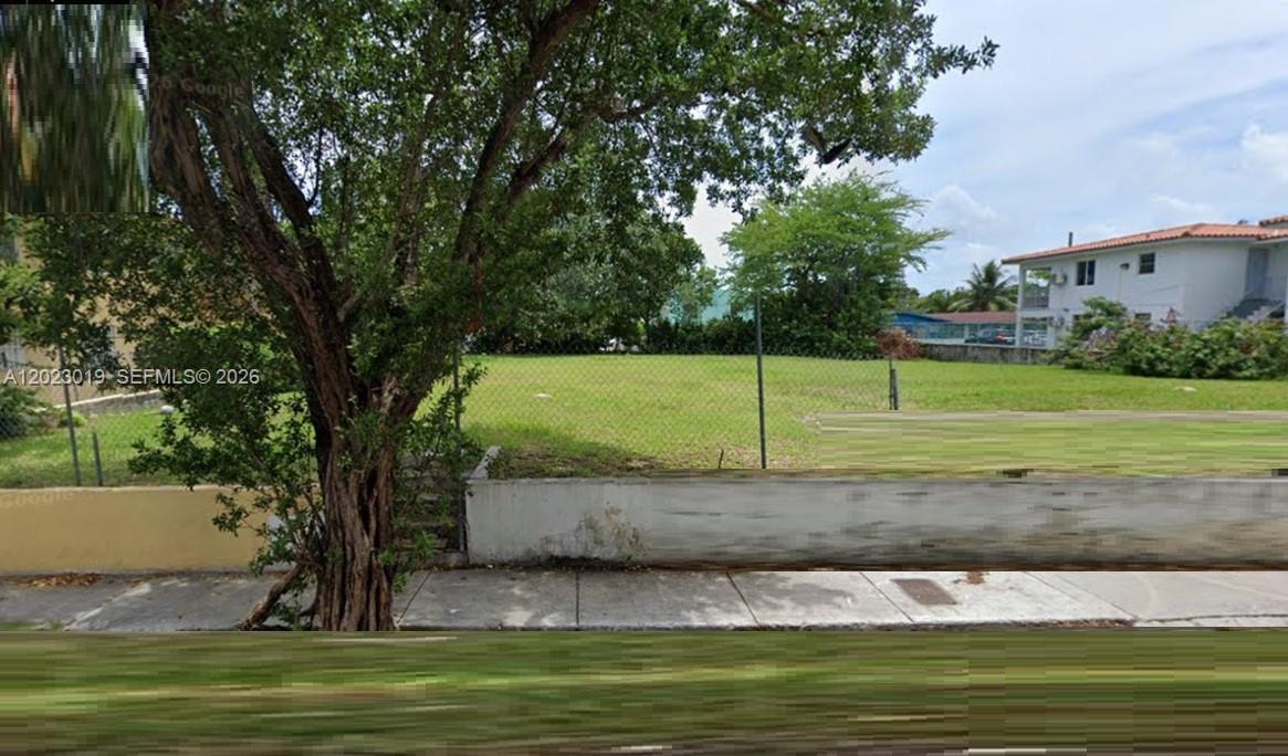 A vacant, grassy residential lot is enclosed by a chain-link fence and a concrete wall — 1534 SW 3rd St, Miami FL 33135, MIAMI, FL