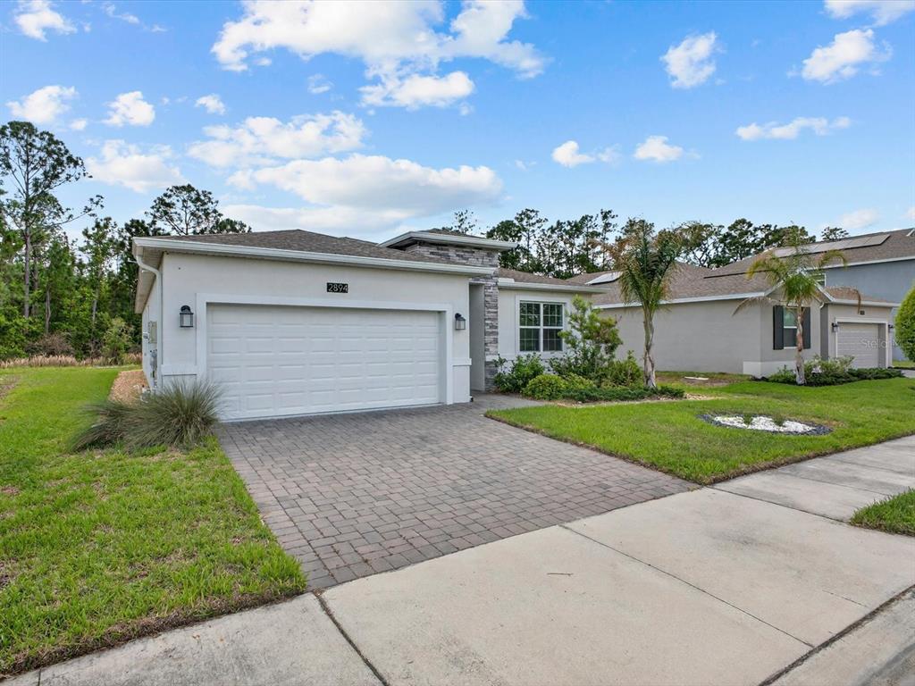Two blue front doors with dark mats sit on a paved entryway with stucco walls — 2894 CAMDEN WAY, DAVENPORT, FL