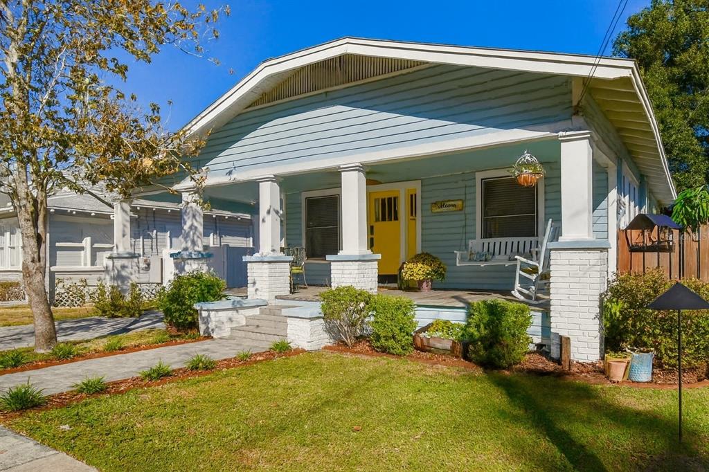 A light blue bungalow with a front porch, white columns, and a bright yellow door — 906 E HAMILTON AVENUE, TAMPA, FL