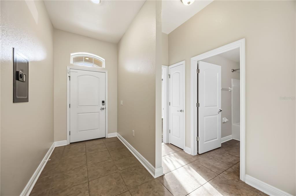 An entryway with tile flooring, a white front door, and two interior doors — 9984 SPRING GULCH LANE, PUNTA GORDA, FL