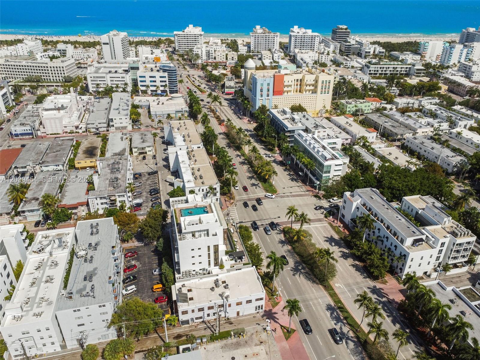 An aerial view shows a city street lined with buildings, palm trees, and a distant beach — 819 5th St, Miami Beach FL 33139, MIAMI BEACH, FL