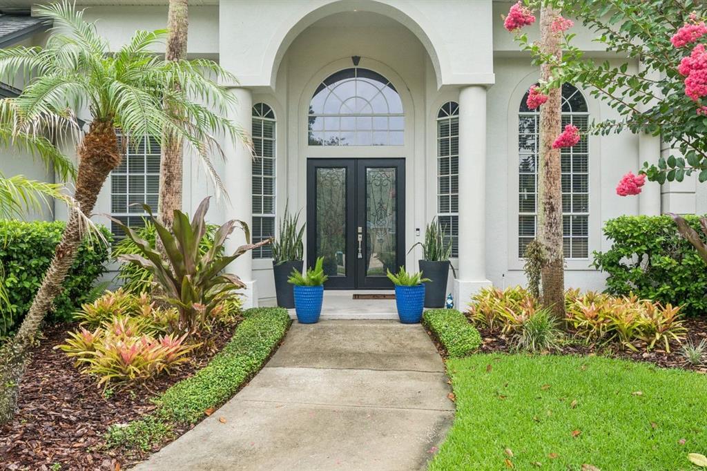 A concrete walkway leads to the double front doors of a house with white columns — 1647 EAGLE NEST CIRCLE, WINTER SPRINGS, FL
