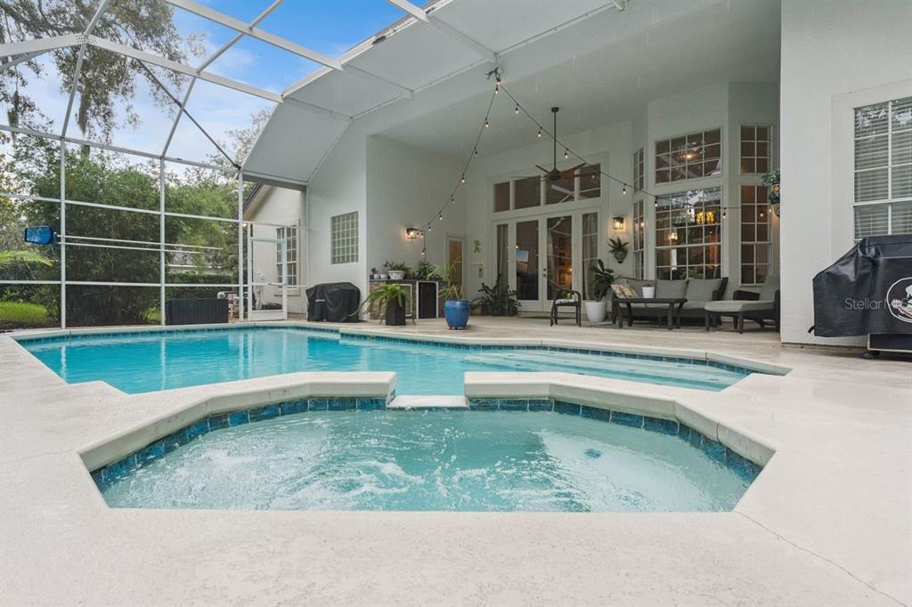 A screened-in patio features a swimming pool, a hot tub, and outdoor seating — 1647 EAGLE NEST CIRCLE, WINTER SPRINGS, FL