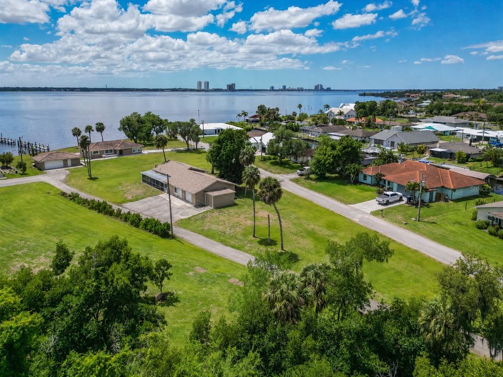 An aerial view shows several houses on a grassy lot near a large body of water — 1808 STEVENSON ROAD, NORTH FORT MYERS, FL