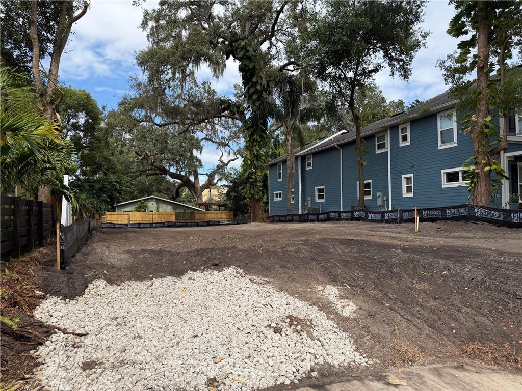 A vacant, cleared residential lot with a gravel patch and a blue building nearby — 1105 ELMWOOD STREET, ORLANDO, FL