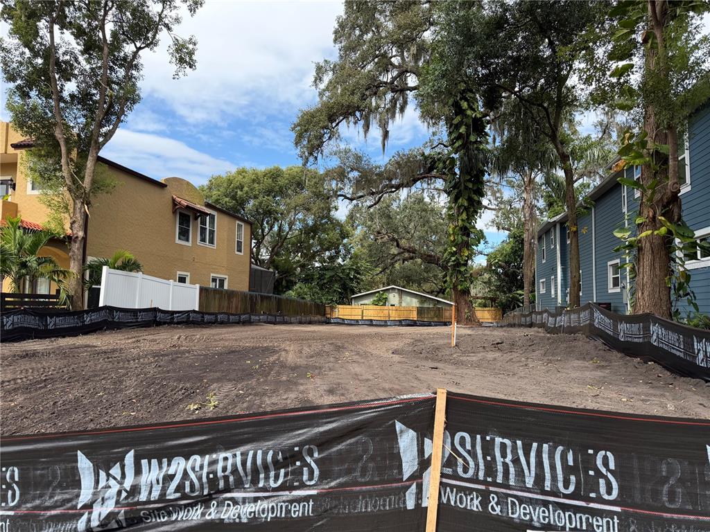 A vacant, cleared lot is situated between two residential buildings with silt fencing installed — 1105 ELMWOOD STREET, ORLANDO, FL