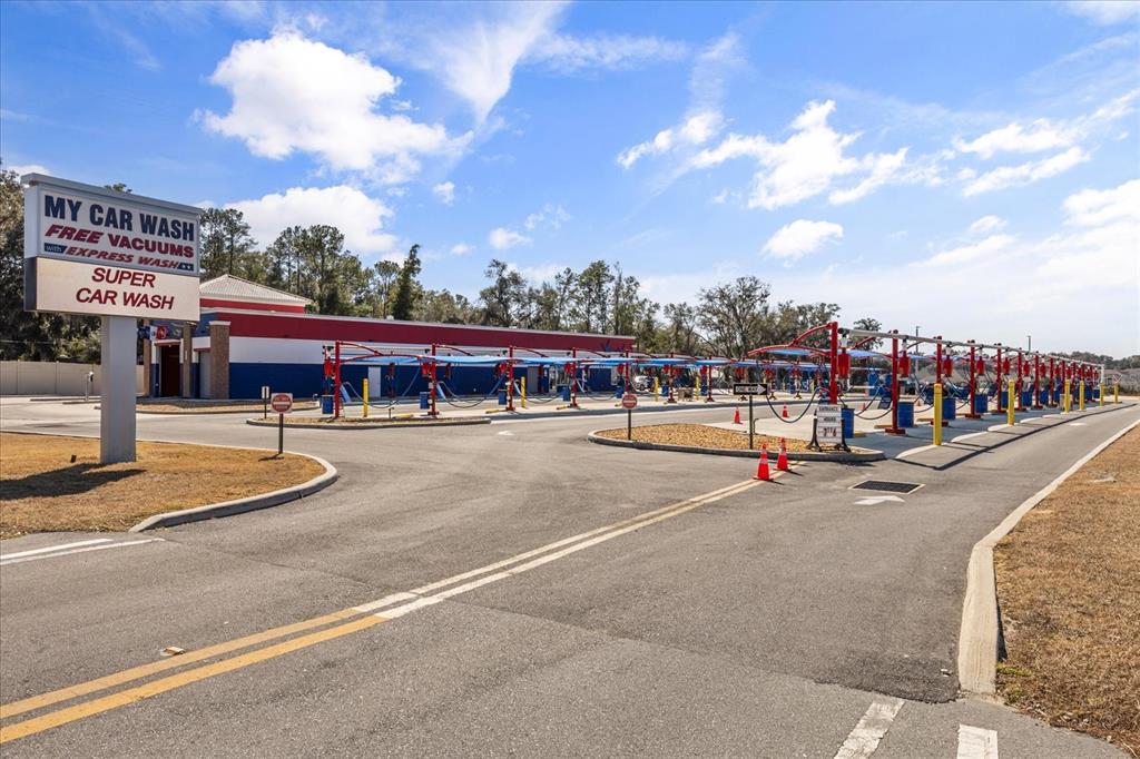 An outdoor view of a car wash facility with a sign and vacuum stations — 9820 SE US HIGHWAY 441, BELLEVIEW, FL
