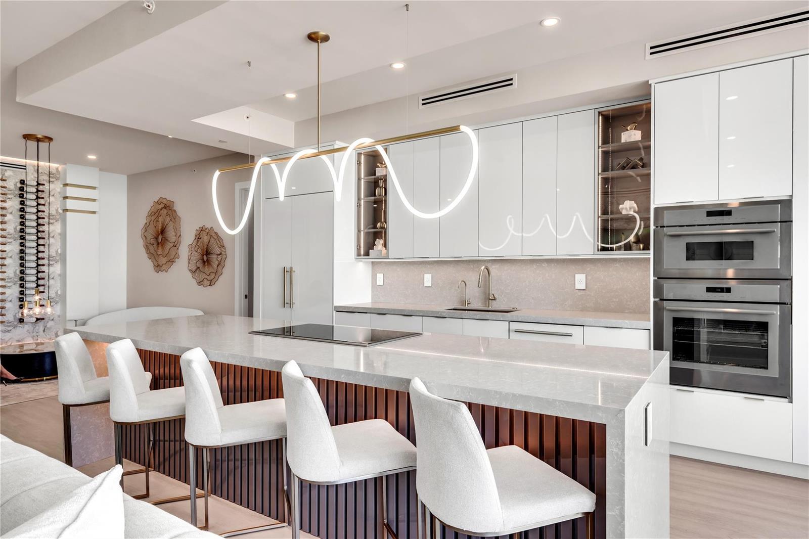 A modern kitchen features a large island with bar seating, white cabinetry, and pendant lighting — 500 SE Mizner Boulevard # A902, Boca Raton FL 33432, BOCA RATON, FL