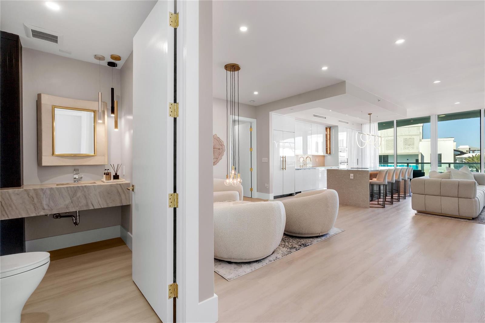 A modern interior view showing a bathroom, living area, and kitchen with light wood floors — 500 SE Mizner Boulevard # A902, Boca Raton FL 33432, BOCA RATON, FL