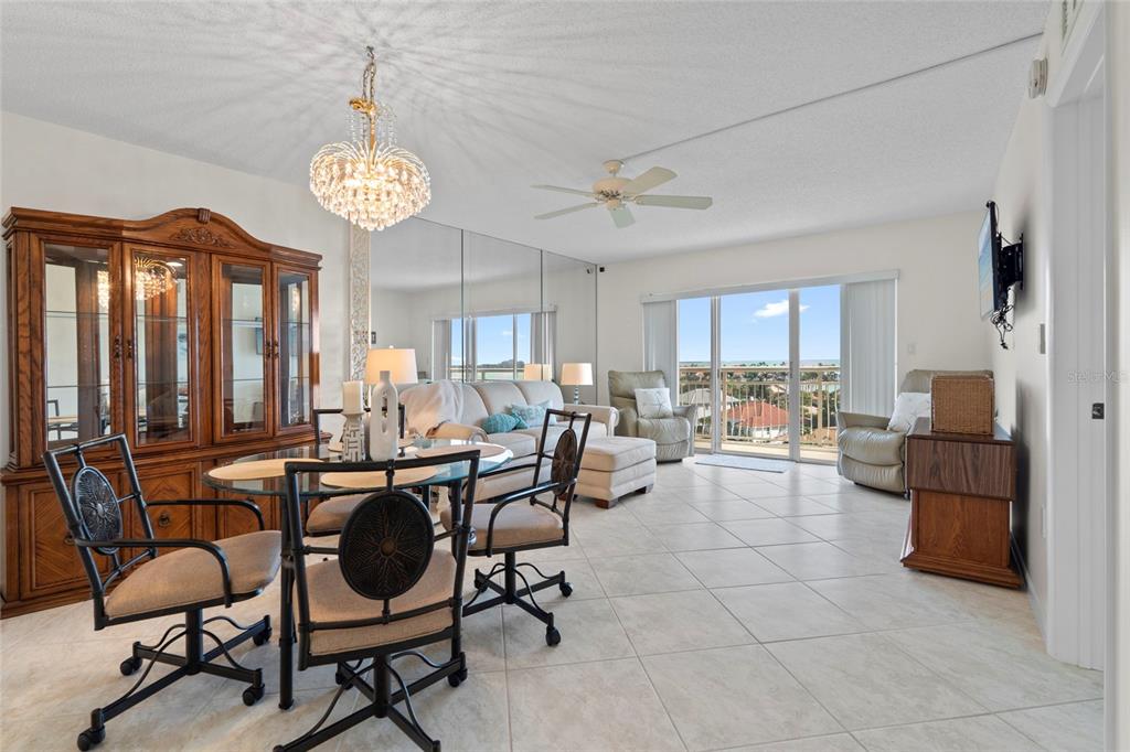 A dining and living area features tile floors, a mirrored wall, and a balcony view — 4900 BRITTANY DRIVE S UNIT 808, ST PETERSBURG, FL