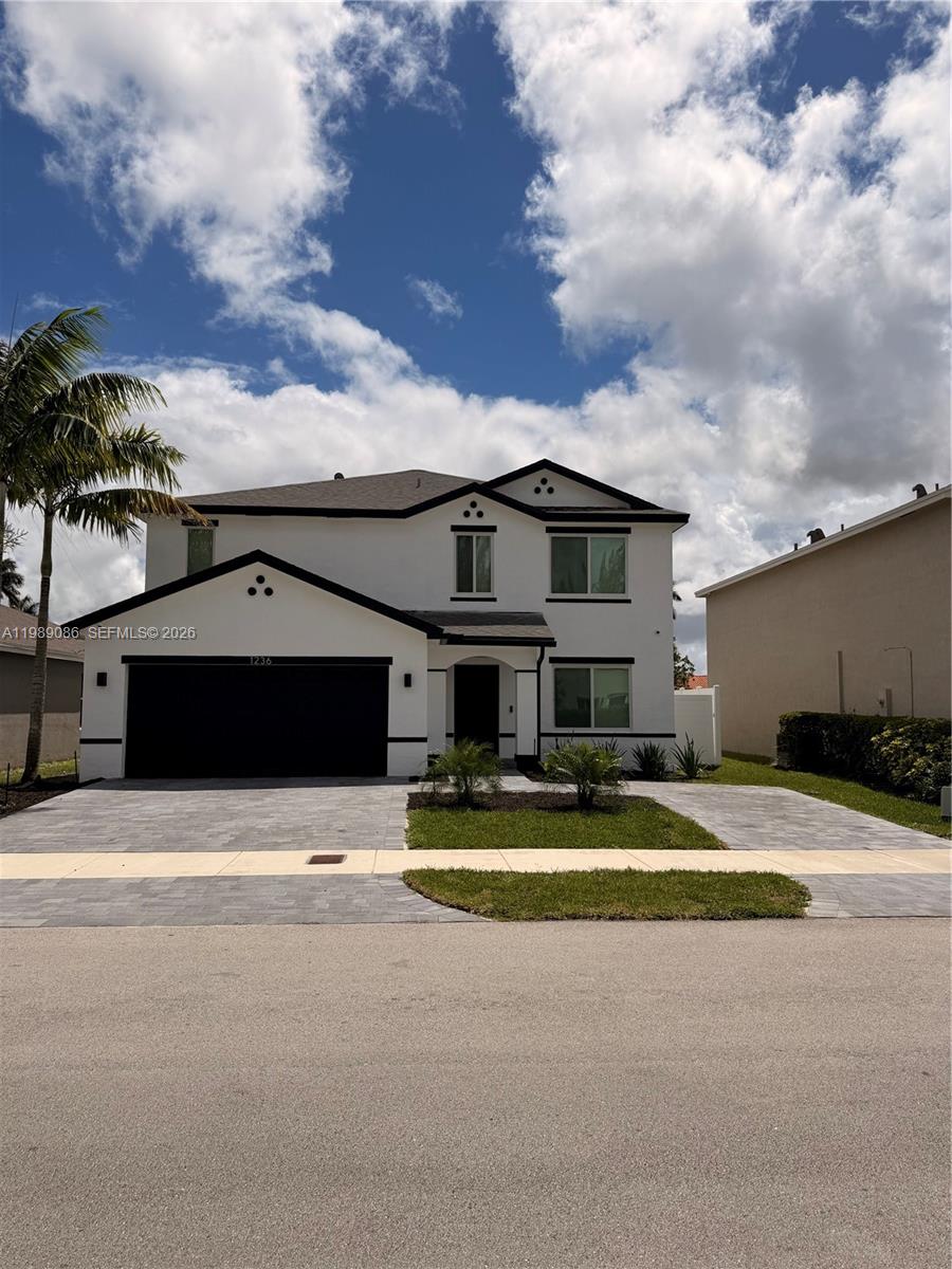 A two-story white house with a black garage door and a paved driveway — 1236 NW 208th St, Miami Gardens FL 33169, MIAMI GARDENS, FL