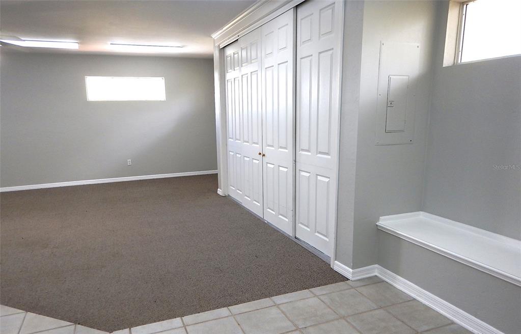 A room with carpeted flooring, white sliding closet doors, and a built-in bench seat — 3921 NW 97TH BOULEVARD UNIT 202, GAINESVILLE, FL