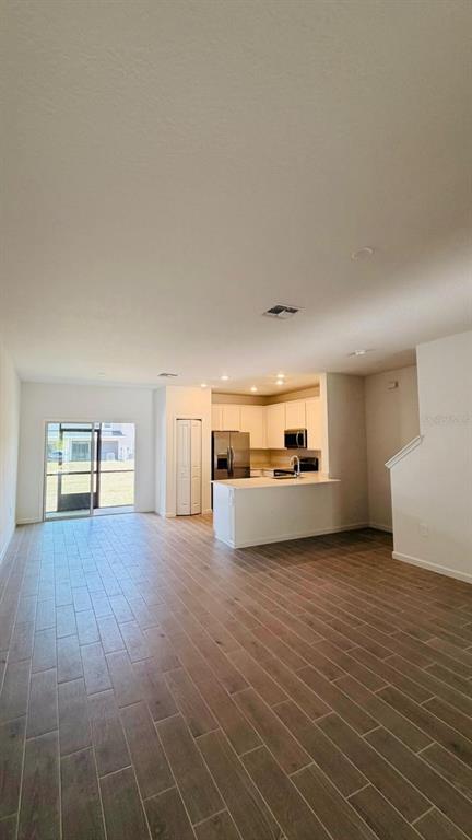 An open-concept kitchen with white cabinets and a breakfast bar overlooks a spacious living area — 3649 SE 37TH CT UNIT CT, OCALA, FL
