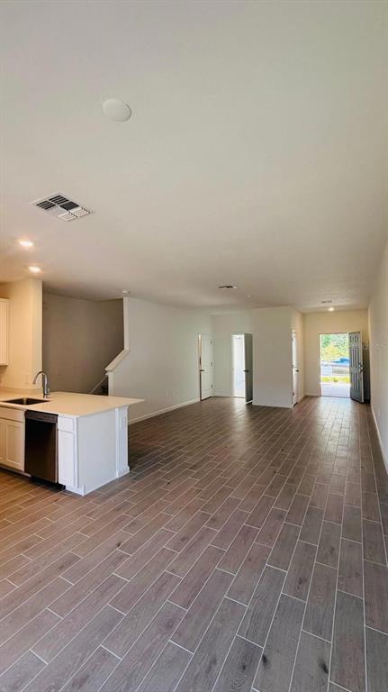 An open-concept kitchen and living area features wood-look tile flooring and a white island — 3649 SE 37TH CT UNIT CT, OCALA, FL