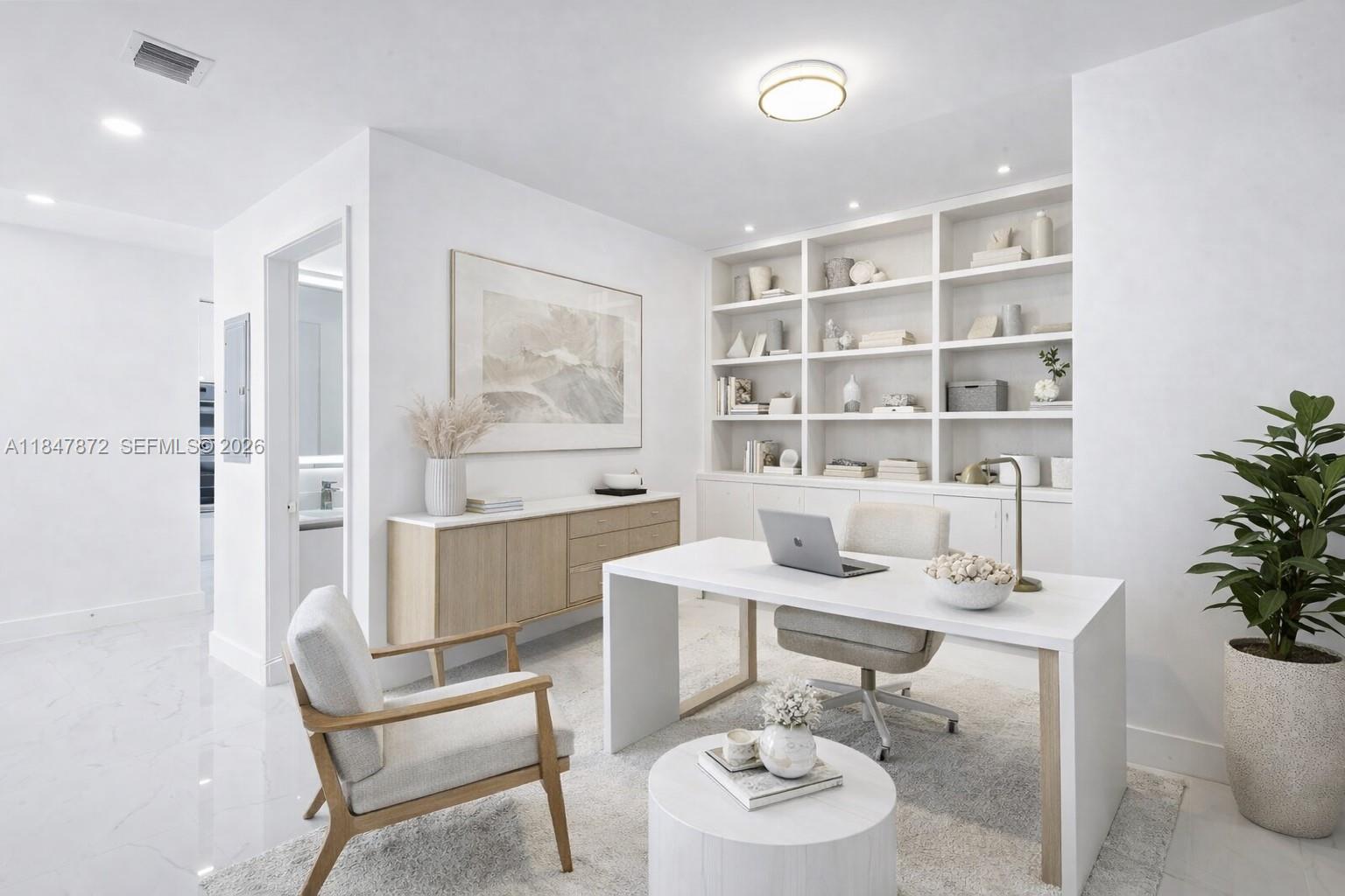 A modern home office features a white desk, built-in shelving, and light wood accents — 700 NE 24th ST # 3502, Miami FL 33137, MIAMI, FL
