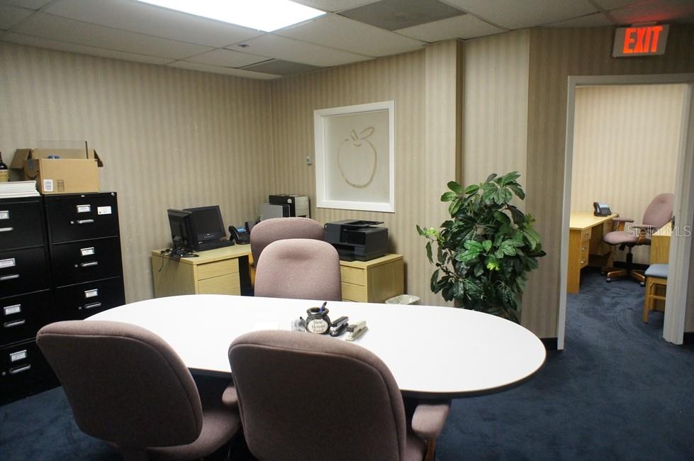 An office space features a conference table, chairs, filing cabinets, and an adjacent room — 2101 STATE RD 434, LONGWOOD, FL