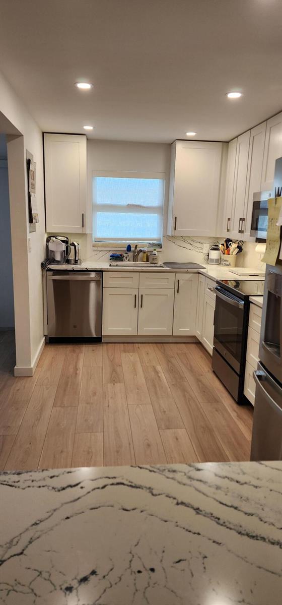 A kitchen with white cabinets, stainless steel appliances, and a white marble-patterned quartz countertop — 299 N Riverside Drive # 604, Pompano Beach FL 33062, POMPANO BEACH, FL