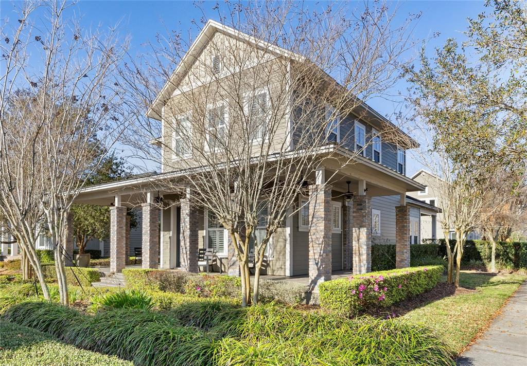 A two-story house with a wrap-around porch, stone columns, and gray siding — 14025 HENCH LANE, ORLANDO, FL