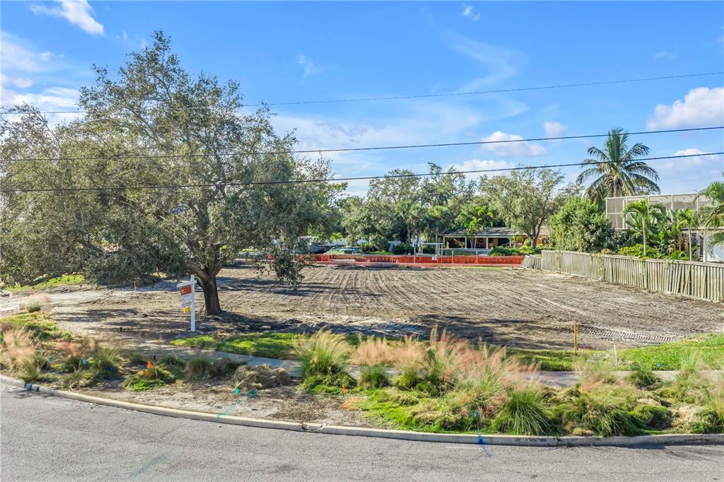 A vacant, cleared residential lot features a large tree and a real estate sign — 4811 PARADISE WAY S, ST PETERSBURG, FL