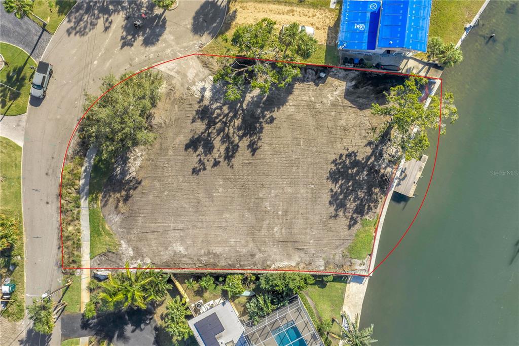 An aerial view shows a vacant, cleared waterfront lot outlined in red — 4811 PARADISE WAY S, ST PETERSBURG, FL