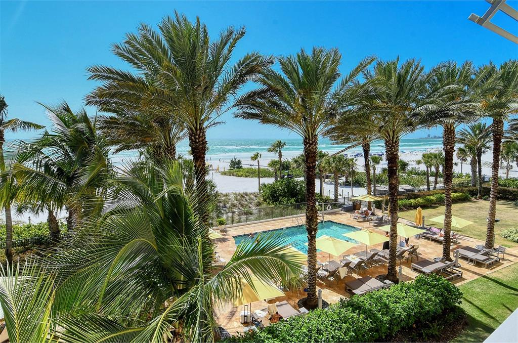 An elevated view of a swimming pool surrounded by palm trees and a sandy beach — 915 SEASIDE DRIVE UNIT 511, Weeks 16-17, SARASOTA, FL