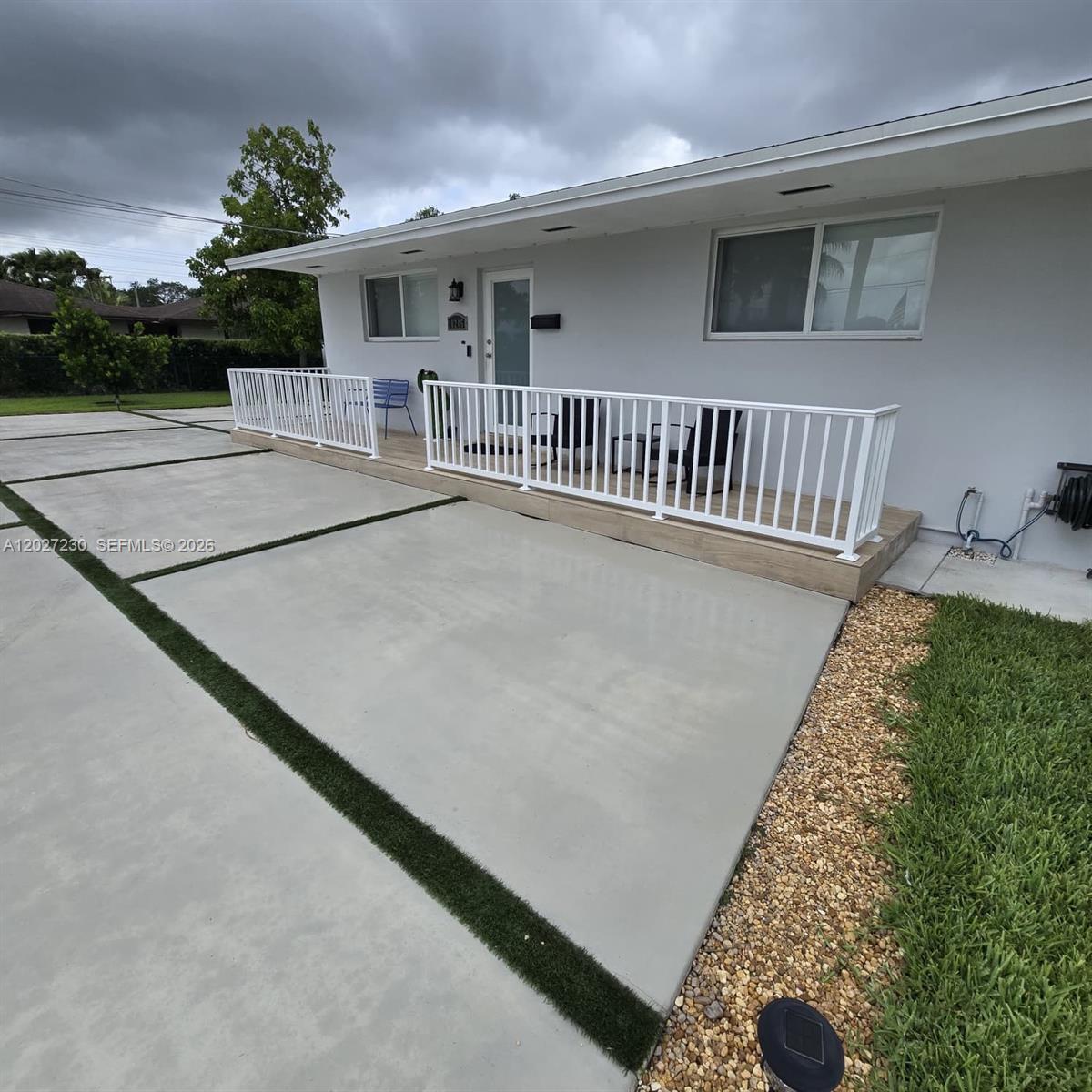 A white house features a front porch with a white railing and a concrete driveway — 10245 SW 68th St # 10245, Miami FL 33173, MIAMI, FL
