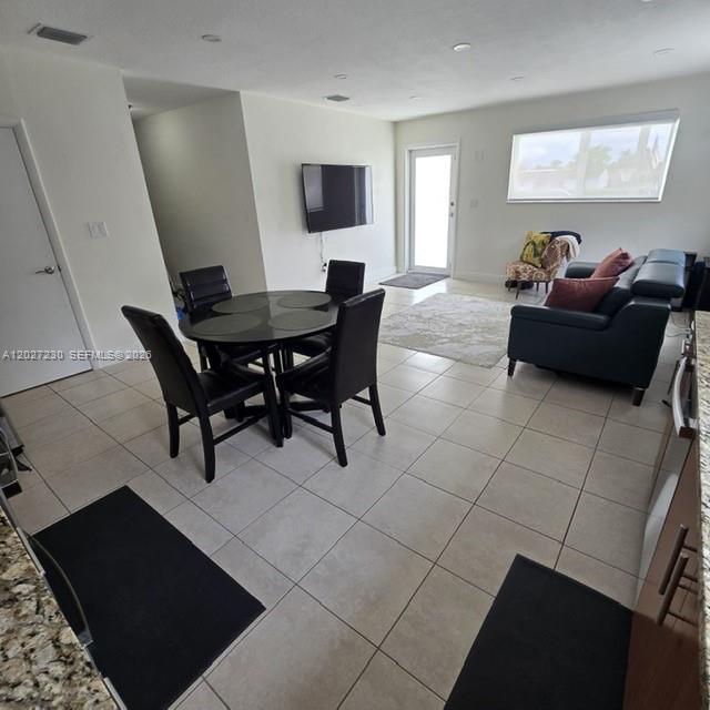 An open-concept living and dining area features tile floors, a dark dining set, and furniture — 10245 SW 68th St # 10245, Miami FL 33173, MIAMI, FL