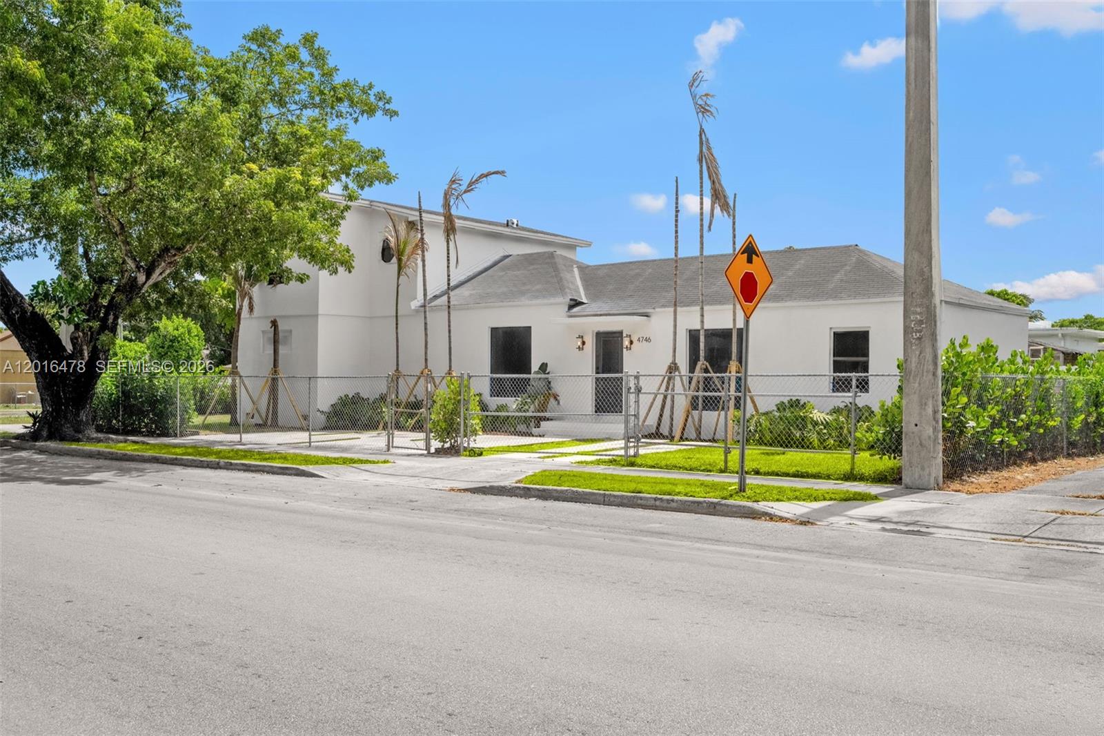 A white, single-story house with a chain-link fence and a tall utility pole outside — 4746 NW 10th Ave, Miami FL 33127, MIAMI, FL