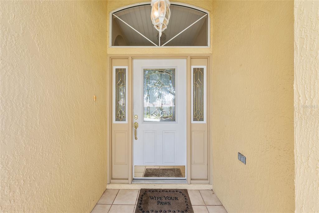 A front entryway features a white door with glass panels, sidelights, and a transom window — 11262 SW 73RD CIRCLE, OCALA, FL