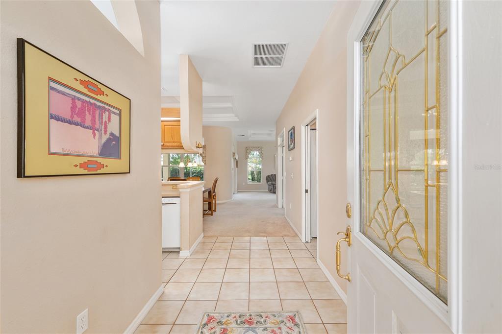 An entryway with tile flooring leads into a carpeted living area and a kitchen — 11262 SW 73RD CIRCLE, OCALA, FL
