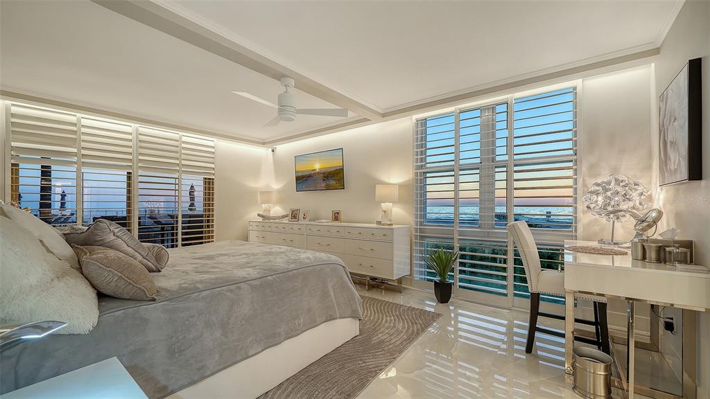 A modern bedroom features a bed, white dresser, desk, and large windows overlooking the ocean — 2301 GULF OF MEXICO DRIVE UNIT 12N and 11N, LONGBOAT KEY, FL